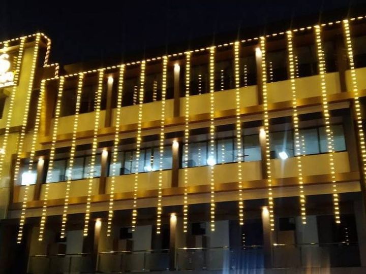 The hotel building at night outlined with strings of yellow lights
