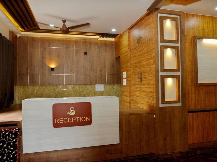 Reception desk with the Samay logo, a wood-panelled wall and lit niches