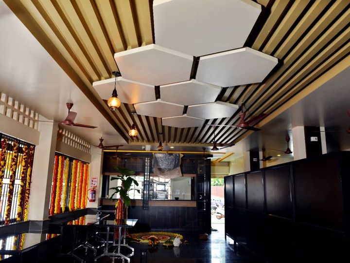 Room with a dark glossy counter, hexagonal ceiling panels and flower garlands on the windows