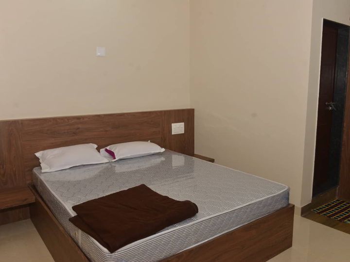 Double bed with a folded towel, a wooden headboard and a side table